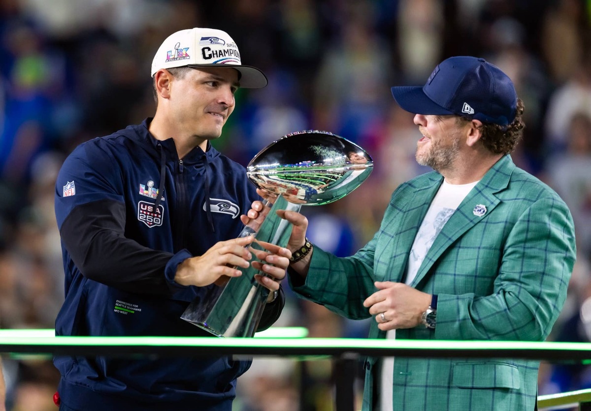  Seahawks head coach Mike MacDonald (left) hands general manager John Schneider the Vince Lombardi trophy on the podium after defeating the New England Patriots in Super Bowl LX at Levi's Stadium. (Credit: Mark J. Rebilas-Imagn Images)