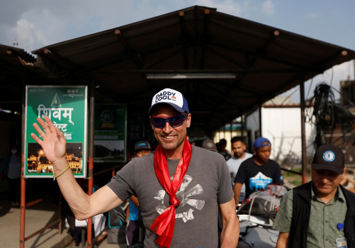British climber Kenton Cool, 49, waves towards the media personnel, upon his arrival at the airport, as he returns after completing his 17th ascent of Mount Everest, which is the most by any foreign climber, in Kathmandu, Nepal May 19, 2023. REUTERS/Navesh Chitrakar