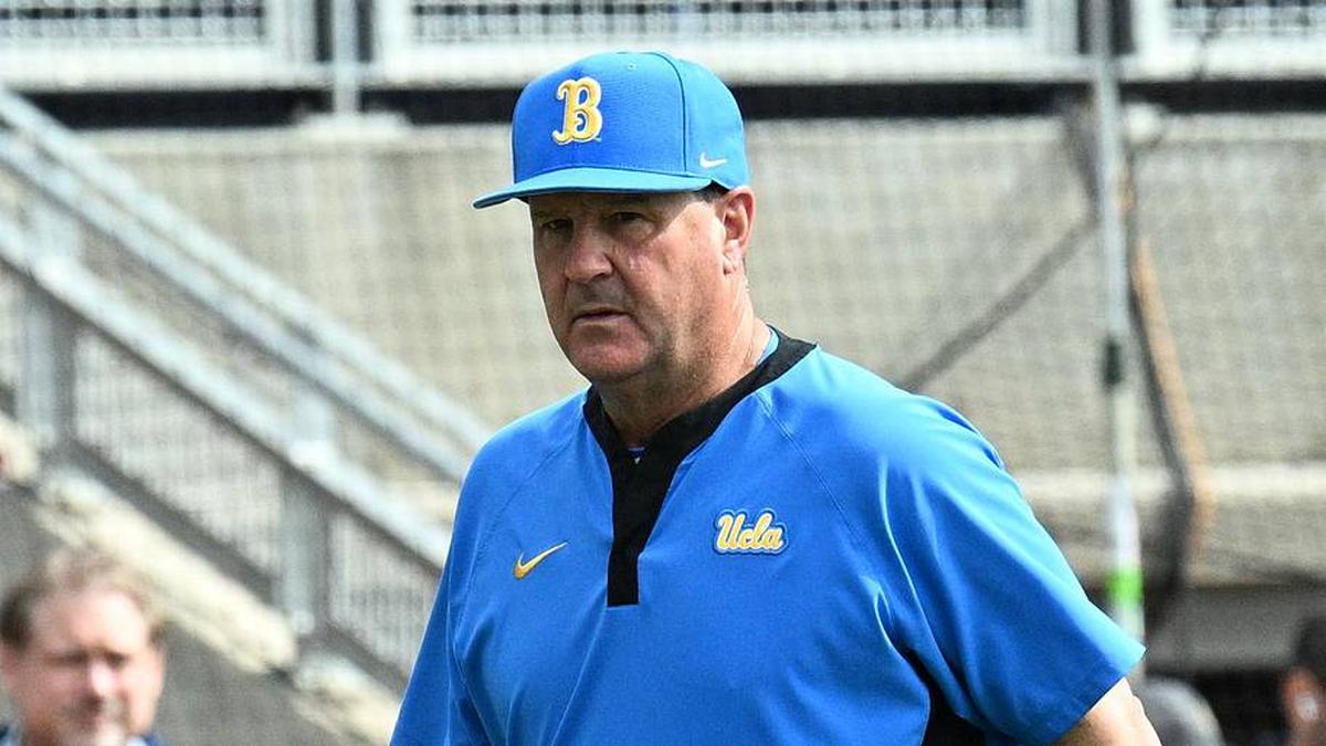  Jun 17, 2025; Omaha, Neb, USA; UCLA Bruins head coach John Savage (22) walks to the dugout before the restart of the game against the LSU Tigers at Charles Schwab Field. Mandatory Credit: Steven Branscombe-Imagn Images | Steven Branscombe-Imagn Images 