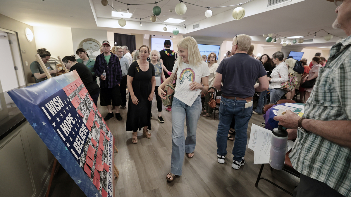 Folks leave messages on a collage (left) during and after the Cooper River Indivisible general meeting at the Haddonfield United Methodist Church on June 9, 2026. The poster will be part of an exhibit at Perkins Center for the Arts. (Elizabeth Robertson/The Philadelphia Inquirer/TNS)