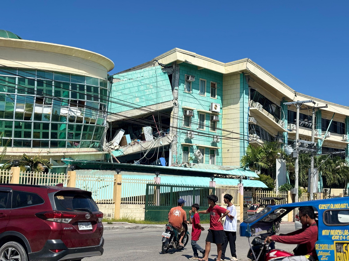 People move near damaged buildings after a magnitude 7.8 quake in General Santos, Mindanao Island, Philippines, June 8, 2026. Picture taken with a mobile phone. GenSan DEV/Handout via REUTERS