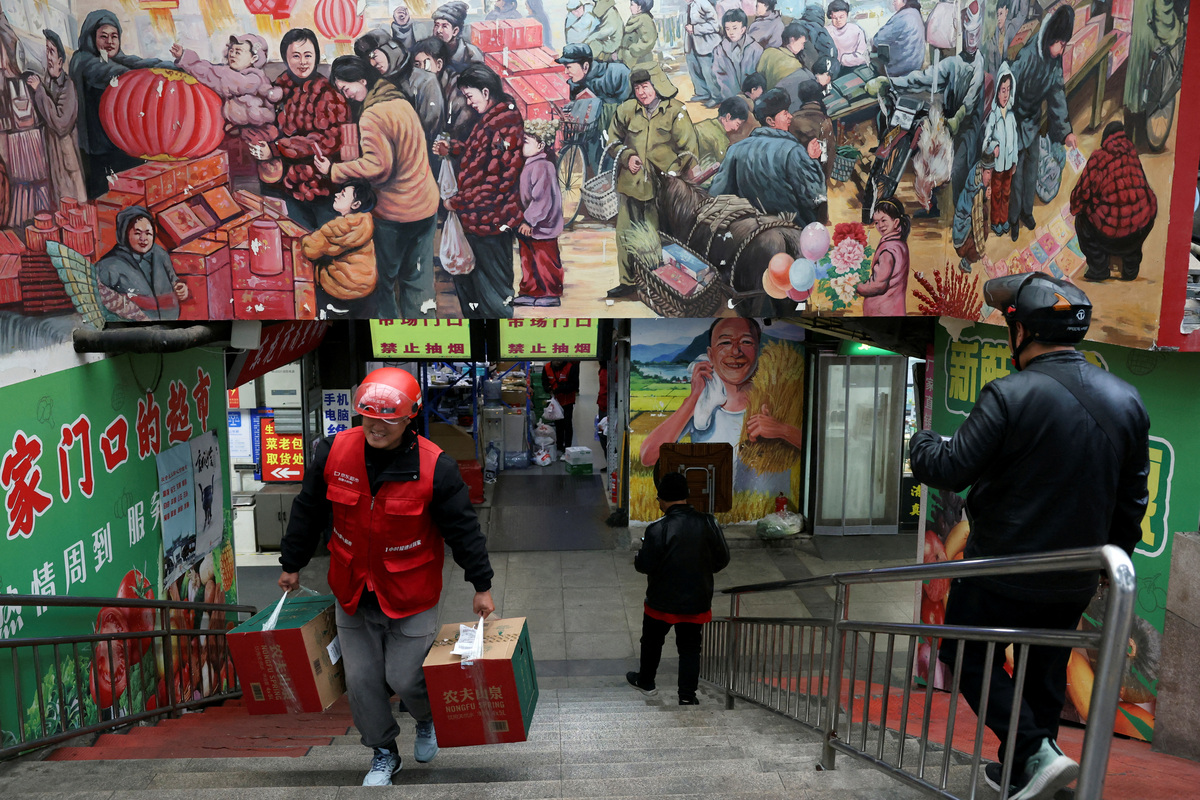 FILE PHOTO: A JD.com delivery worker picks up grocery orders from a market in Beijing, China October 17, 2024. REUTERS/Florence Lo/File Photo
