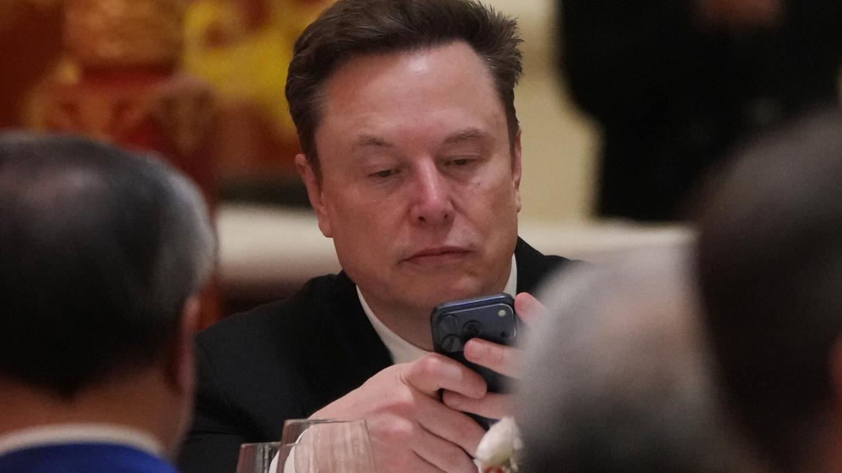 Trump China. Elon Musk uses his phone during a state dinner for President Donald Trump and Chinese President Xi Jinping at the Great Hall of the People on Thursday May 14, 2026, in Beijing. (AP Photo/Mark Schiefelbein)