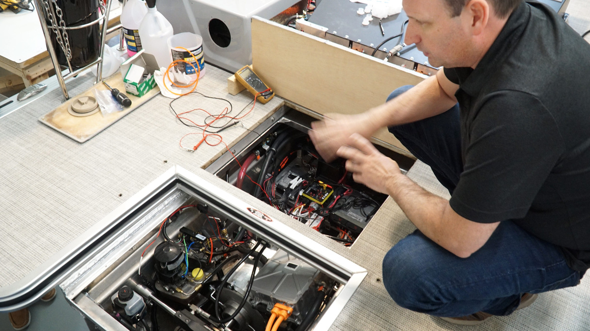 Hercules Electric Mobility CEO James Breyer is installing a battery-electric powered 250 horsepower motor on a ponton boat in their Farmington Hills facility in 2022.
