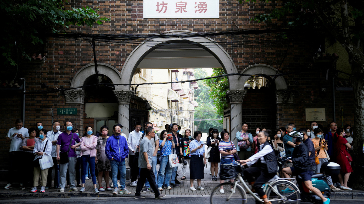 FILE PHOTO: Parents wait for students behind a police line during the annual national college entrance exam, or "gaokao",  at a high school in Shanghai, China June 7, 2023. REUTERS/Aly Song/File Photo