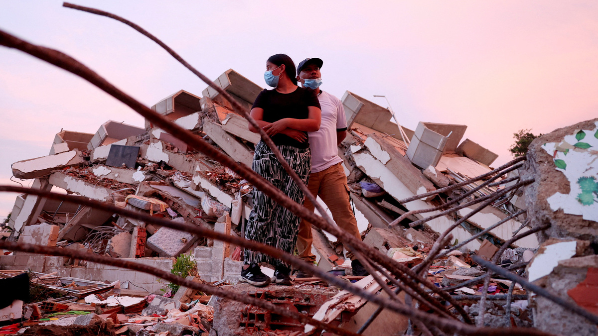 Yohancy Gil, 24 and her husband Sergio Guanipa, 30, stand on rubble as they wait for news from rescue teams looking for their children under the rubble at the site of a collapsed building in the aftermath of earthquakes, in La Guaira, Venezuela, June 30, 2026. REUTERS/Ricardo Arduengo