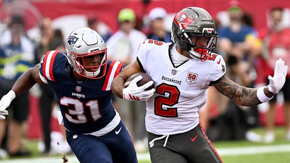  Nov 9, 2025; Tampa, Florida, USA; Tampa Bay Buccaneers wide receiver Emeka Egbuka (2) runs for a gain past New England Patriots safety Craig Woodson (31) and cornerback Marcus Jones (25) during the first quarter at Raymond James Stadium. Mandatory Credit: Jonathan Dyer-Imagn Images | Jonathan Dyer-Imagn Images 