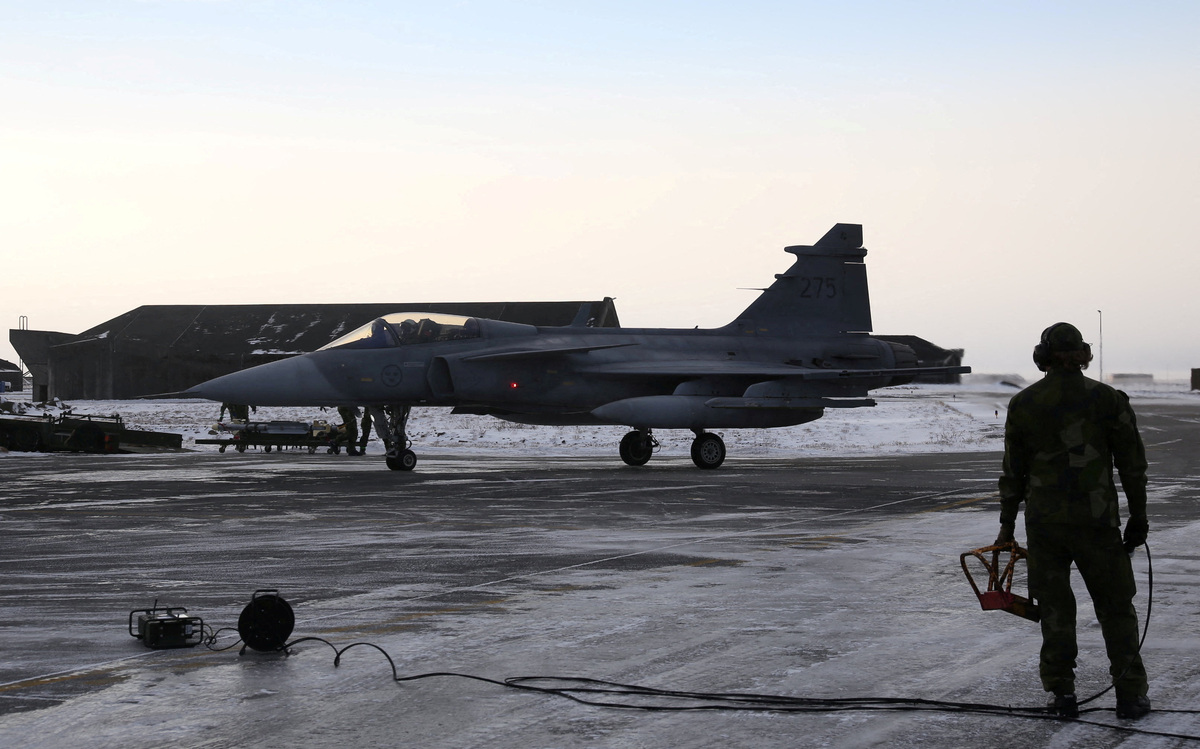 FILE PHOTO: A Swedish ground crew member watches as a JAS 39 Gripen approaches on the tarmac at the air base in Keflavik, Iceland, March 3, 2026. REUTERS/Tom Little/File Photo