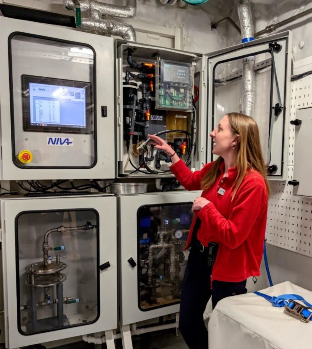  Meagan Goggins, the chief scientist aboard the Viking Polaris, shows off the”Ferry Box,” which takes water samples every minute of every day, recording data such as water temperature and microplastics concentration. Photo credit: Cindy Richards 