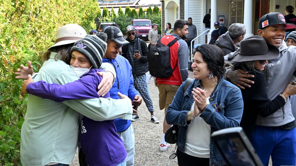 Carlos Muñoz abraza a Larkin Stallings de Vineyard Haven, Massachusetts, mientras los inmigrantes se preparan para salir de St. Andrews en Edgartown, Massachusetts, el viernes 16 de septiembre de 2022. El gobernador de Florida, Ron DeSantis, siguió el ejemplo de un colega republicano, el gobernador Greg Abbott de Texas, al mandar dos aviones llenos de inmigrantes venezolanos a Martha’s Vineyard, Massachusetts. Los migrantes fueron trasladados voluntariamente a una base militar en las cercanías de Cape Cod, Massachusetts. (Ron Schloerb/Cape Cod Times vía AP)