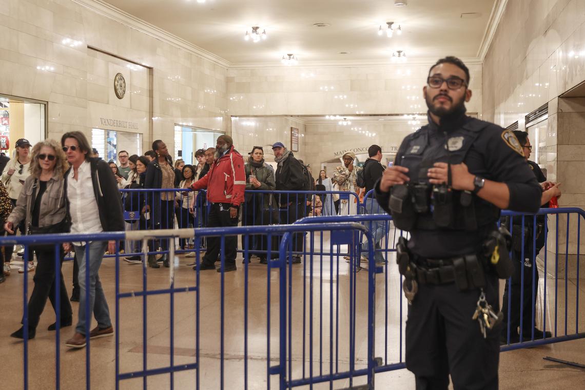 Pedestrians look on at a closed Subway station inside Grand Central Terminal in Manhattan following a reported stabbing and police shooting on Saturday, April 11, 2026. A person was reportedly stabbed in the head on the platform of the uptown 4, 5 and 6 trains; an officer who had been called to the platform then shot the attacker. Both were in critical condition. (Heather Khalifa/The New York Times)
