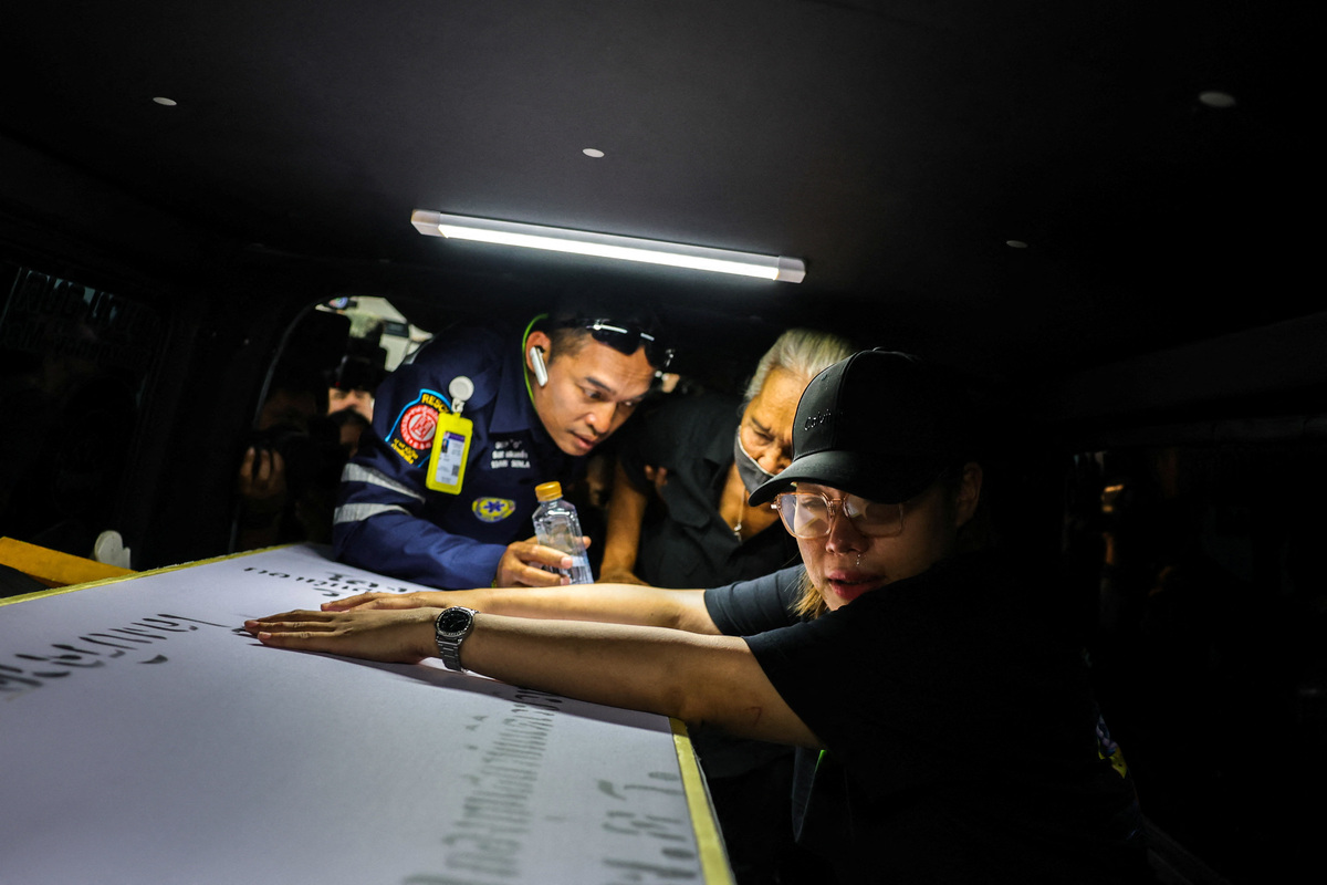 A family member reacts as she receives the body of a victim at the Police Hospital morgue, following a deadly fire at a pub in Bangkok, Thailand, July 14, 2026. REUTERS/Athit Perawongmetha