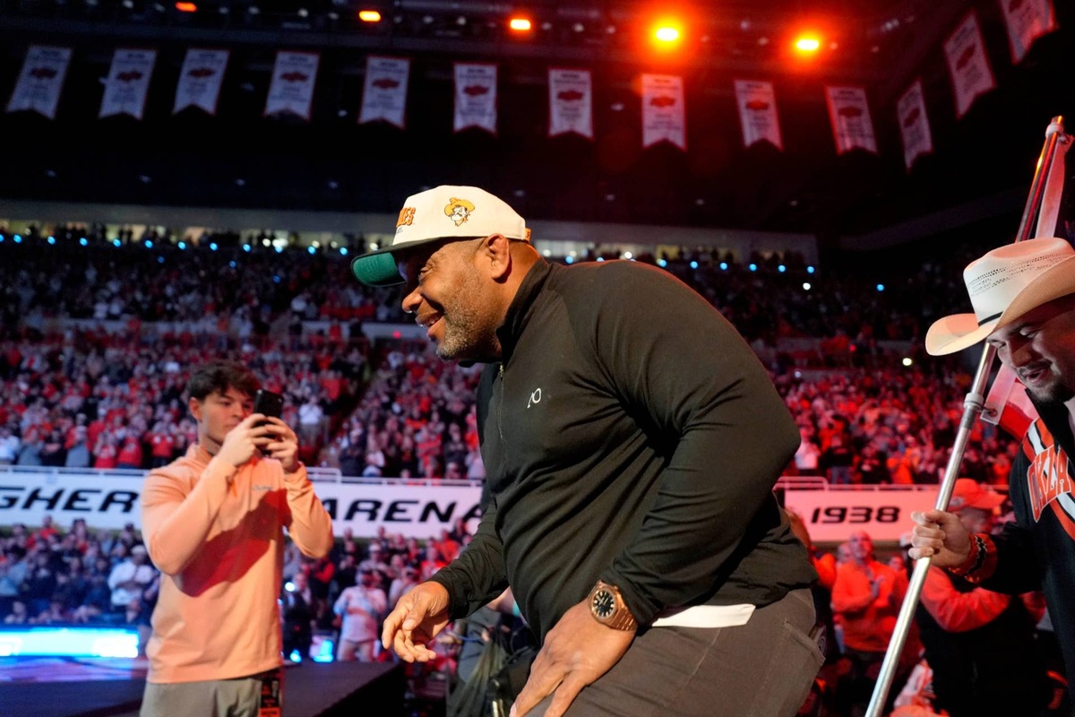  Former Oklahoma State wrestler Daniel Cormier leads the Cowboys out before a college wrestling dual between the Oklahoma State University Cowboys (OSU) and the Iowa Hawkeyes at Gallagher-Iba Arena in Stillwater, Okla., Sunday, Feb. 22, 2026. 
