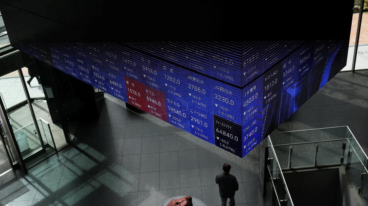 A visitor walks past Japan's Nikkei stock prices quotation board inside a conference hall in Tokyo, Japan March 4, 2026. REUTERS/Issei Kato