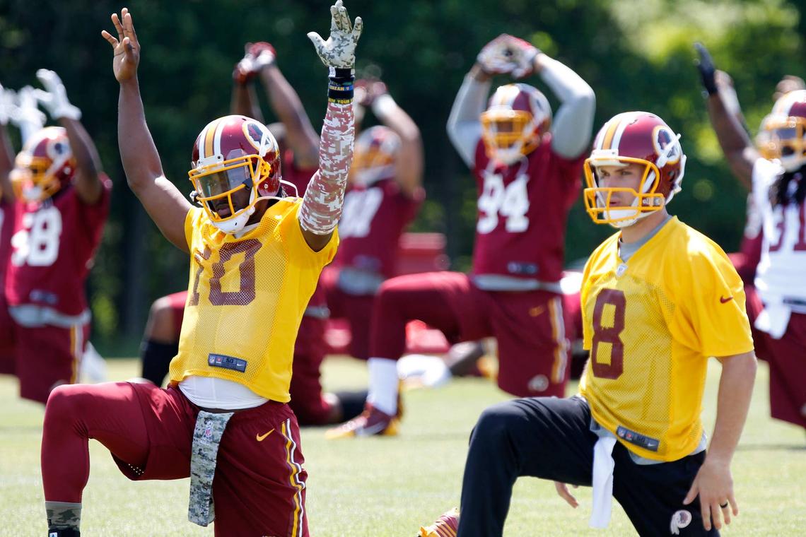  Washington quarterback Robert Griffin III (10) and Redskins quarterback Kirk Cousins (8) warm up during OTAs. (Credit: Geoff Burke-USA TODAY Sports) 