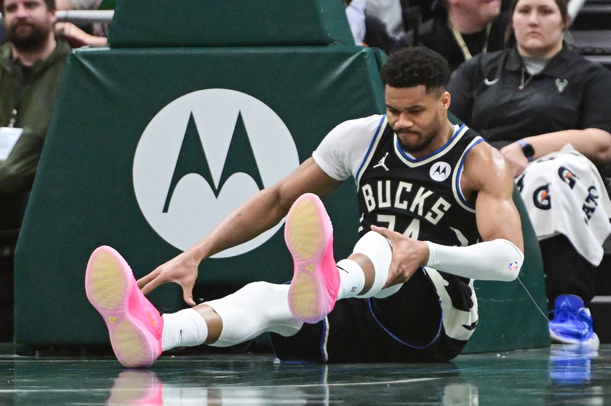  Milwaukee Bucks forward Giannis Antetokounmpo holds his knee after dunking a basket at Fiserv Forum. Benny Sieu-Imagn Images