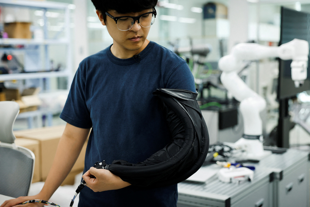 Kim Nam Gyun, a postdoctoral researcher at the Korea Advanced Institute of Science and Technology (KAIST) and soft robotics engineer, demonstrates a sleeve prototype of a self-dressing robot at KAIST in Daejeon, South Korea, July 14, 2026. REUTERS/Kim Soo-hyeon