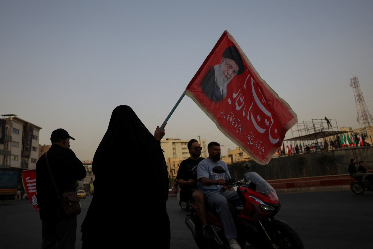 A woman holds a flag with a picture of Iran's late Supreme Leader Ayatollah Ali Khamenei at Revolution Square ahead of a night rally in Tehran, Iran, July 2, 2026. REUTERS/Murad Sezer Foreign media in Iran operate under guidelines set by the Ministry of Culture and Islamic Guidance, which regulates press activity and permissions