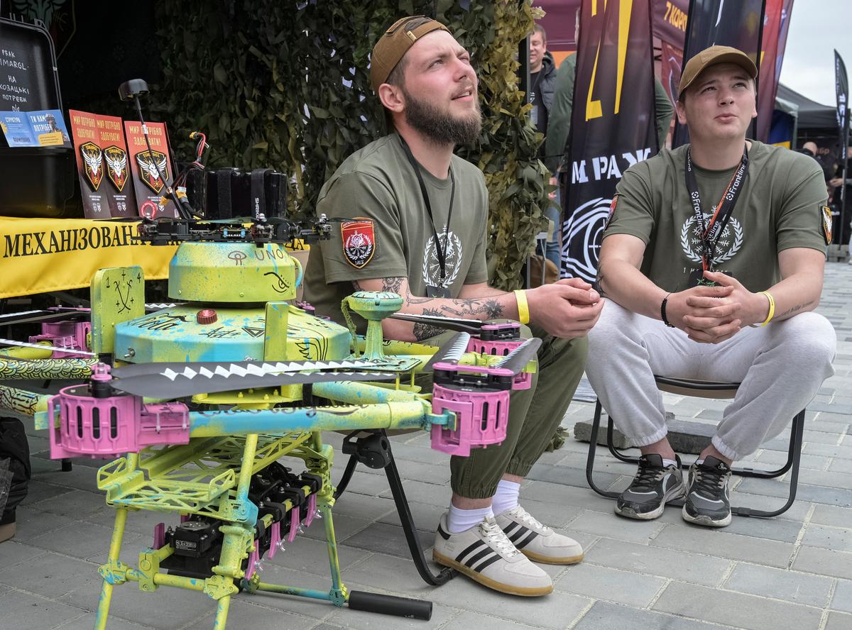 Participants of the Wild Drones competition appear near a painted Vampire heavy combat drone, amid Russia's attack on Ukraine, in the town of Truskavets, Lviv region, Ukraine May 19, 2026. REUTERS/Stringer