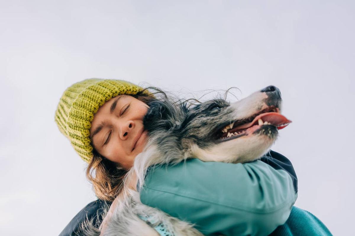  A dog owner being affectionate and showing love to her dog.