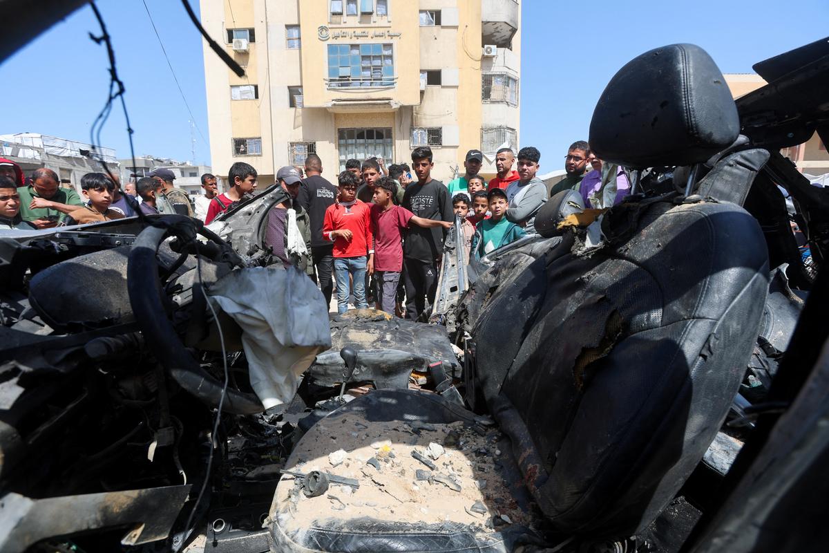 Palestinians inspect the site of an Israeli strike on a car in Khan Younis, in the southern Gaza Strip, May 10, 2026. REUTERS/Ramadan Abed
