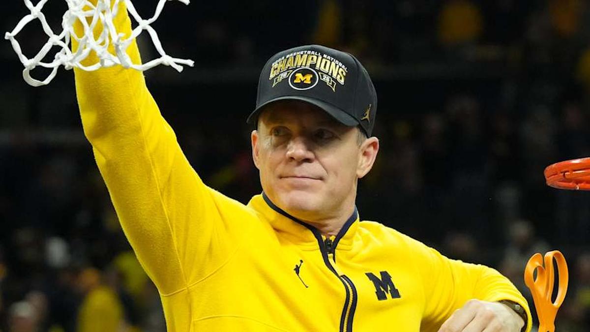  Apr 6, 2026; Indianapolis, IN, USA; Michigan Wolverines head coach Dusty May cuts down the net after defeating the Connecticut Huskies in the national championship of the Final Four of the men's 2026 NCAA Tournament at Lucas Oil Stadium. Mandatory Credit: Robert Deutsch-Imagn Images | Robert Deutsch-Imagn Images 