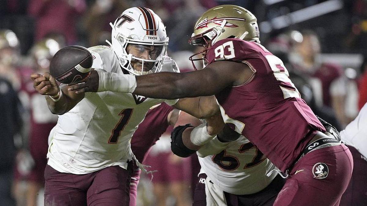  Nov 15, 2025; Tallahassee, Florida, USA; Virginia Tech Hokies quarterback Kyron Drones (1) has the ball knocked away by Florida State Seminoles defensive lineman Mandrell Desir (93) during the second half at Doak S. Campbell Stadium. Mandatory Credit: Melina Myers-Imagn Images | Melina Myers-Imagn Images 