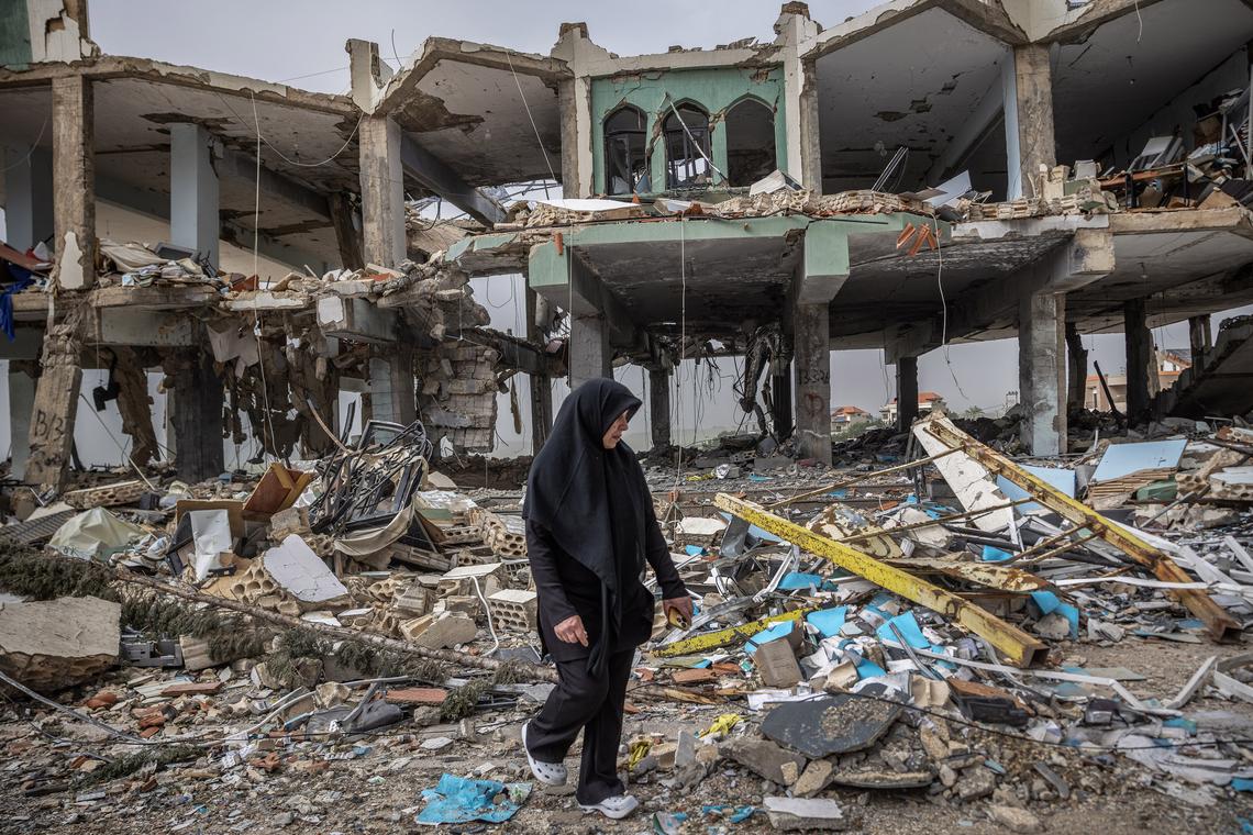 A woman walks through the ruins of a building in the southern Lebanon town of Borj Qalaouiye, as people return after the announcement of a ten-day ceasefire, April 18, 2026. (David Guttenfelder/The New York Times)