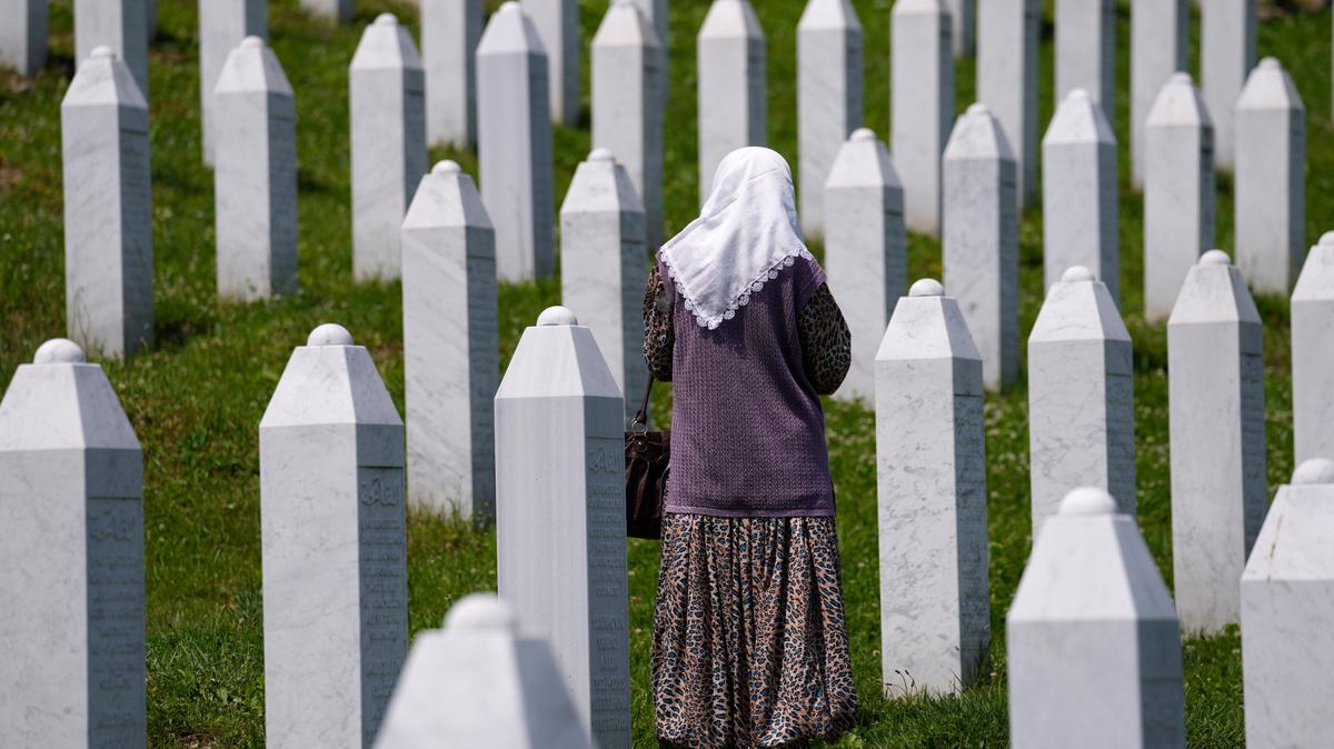 Una mujer camina en el cementerio memorial en donde están enterradas las víctimas de la masacre de Srebrenica, en Potocari, cerca de Srebrenica, al este de Bosnia, el 8 de junio de 2021.