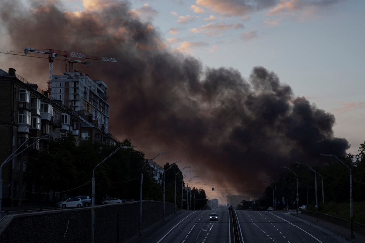 A column of smoke rises over the city as a car drives on a highway following Russian missile strikes, amid Russia’s attack on Ukraine, in Kyiv, Ukraine, July 19, 2026. REUTERS/Thomas Peter