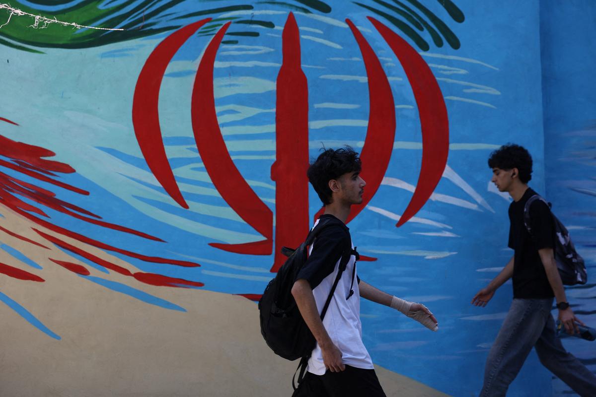 People walk next to a mural on a street in Tehran, Iran, May 11, 2026. Majid Asgaripour/WANA (West Asia News Agency) via REUTERS