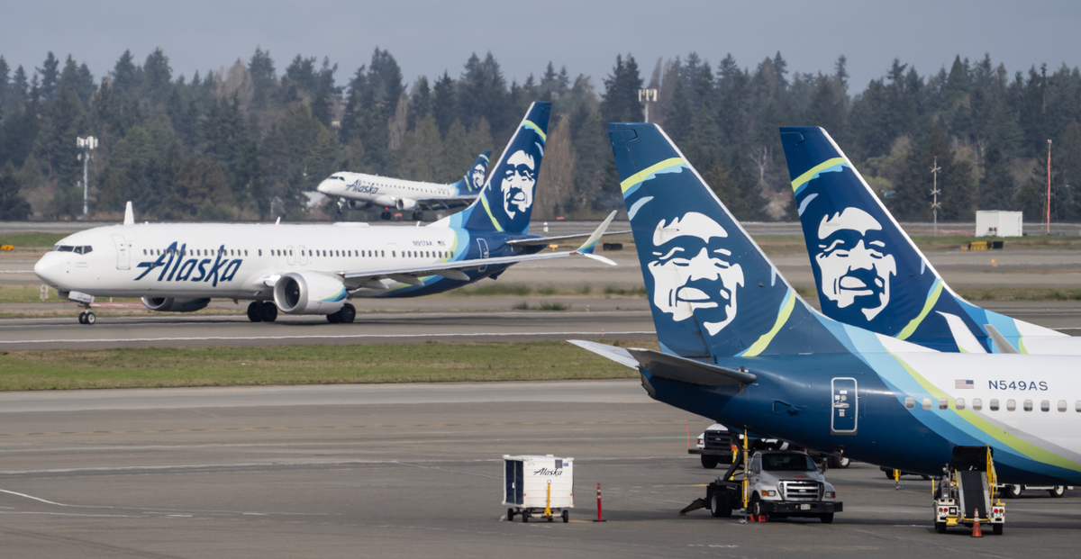 An Alaska Airlines Boeing 737 MAX 9, left, takes off at Seattle-Tacoma International Airport on March 25, 2024, in Seattle.