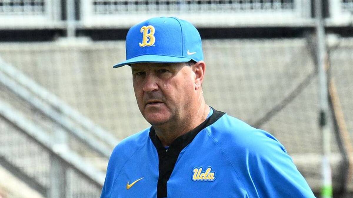  Jun 17, 2025; Omaha, Neb, USA; UCLA Bruins head coach John Savage (22) walks to the dugout before the restart of the game against the LSU Tigers at Charles Schwab Field. Mandatory Credit: Steven Branscombe-Imagn Images | Steven Branscombe-Imagn Images 