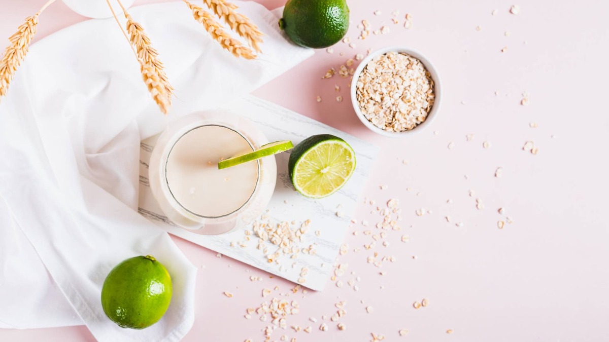 Homemade oatzempic drink of oat milk and lime in a glass on the table. 