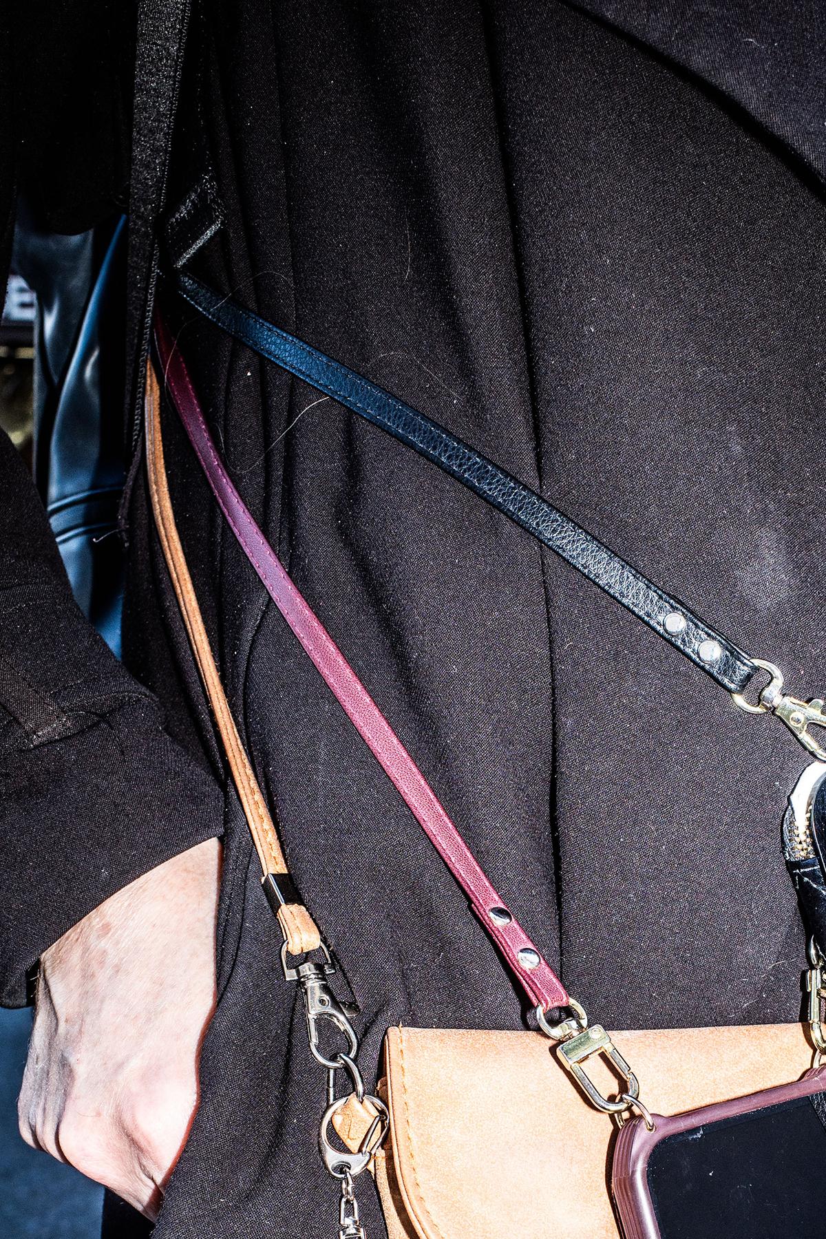 A pedestrian carrying multiple phones on cross-body straps in New York, May 11, 2026. Carrying multiple cellphones, whether for cybersecurity or work-life balance, comes with some quirks and style challenges. (Graham Dickie/The New York Times)