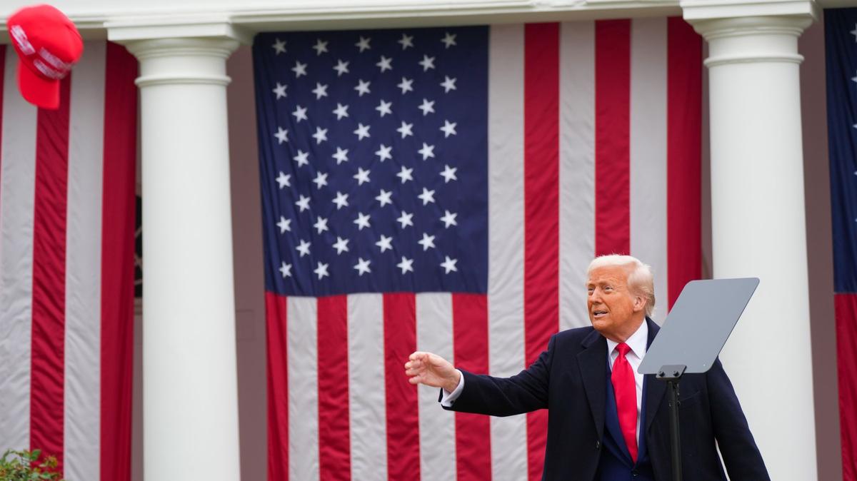 President Donald Trump throws a hat to auto workers as he makes remarks during a 'Make America Wealthy Again' event in the Rose Garden of the White House.