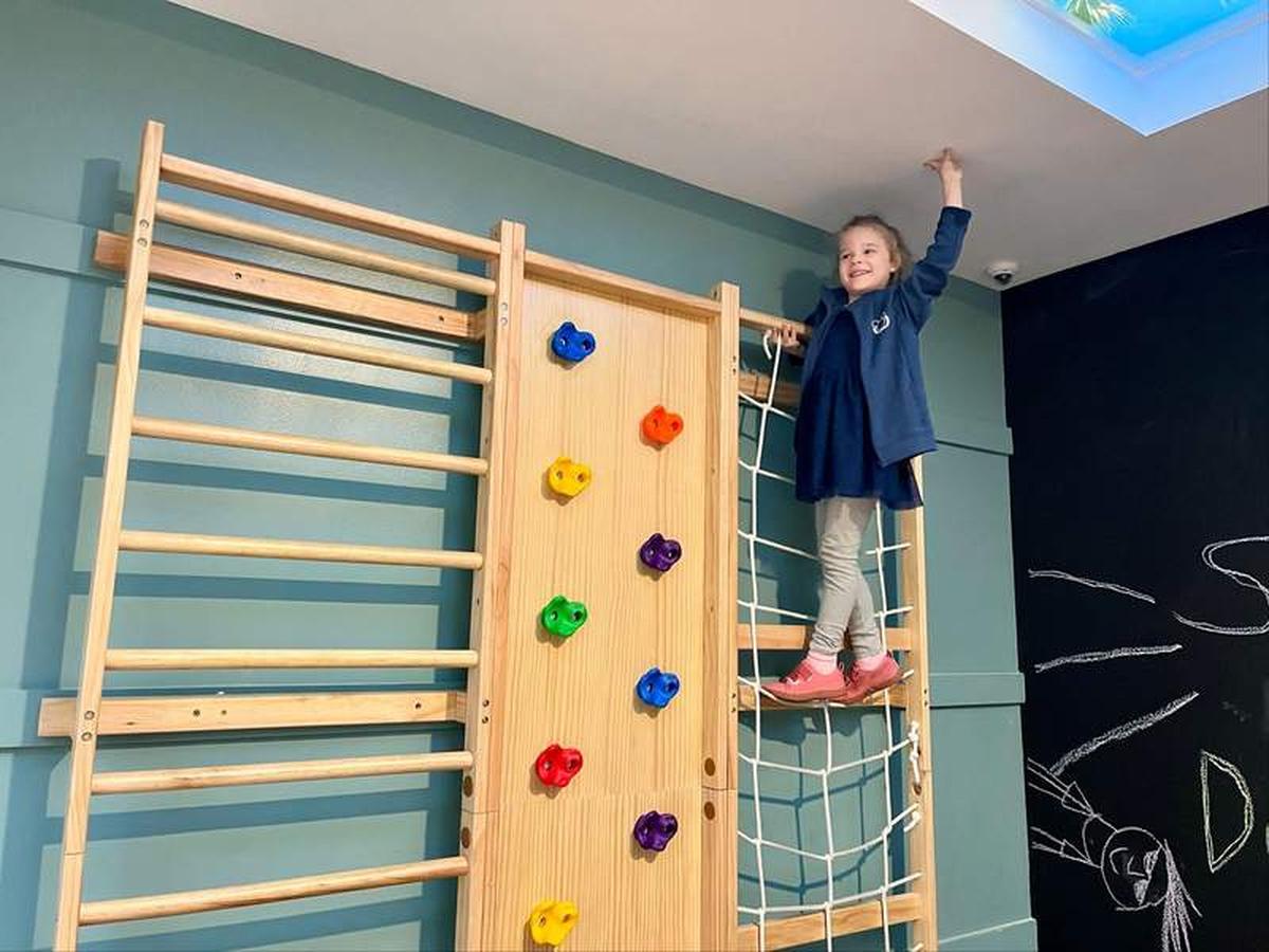  One of the author's children stands at the top of the kid-sized climbing wall inside Camp Dolphin at the Dolphin hotel. Photo credit: Linnea Bailey 