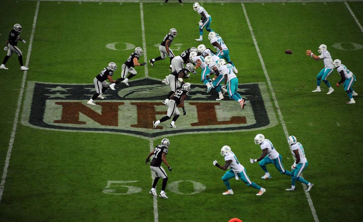  Sep 28, 2014; London, UNITED KINGDOM; General view of the line of scrimmage at midfield on the NFL shield as Miami Dolphins quarterback Ryan Tannehill (17) takes the snap against the Oakland Raiders in the NFL International Series game at Wembley Stadium. The Dolphins defeated the Raiders 38-14. Mandatory Credit: Kirby Lee-USA TODAY Sports 