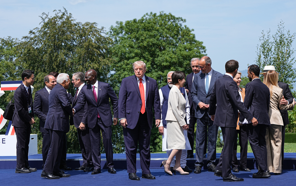 President Donald Trump stands in the center of the stage as world leaders greet each other while gathering for an official photo at the G7 Summit in Evian-les-Bains, France, June 16, 2026. (Haiyun Jiang/The New York Times)