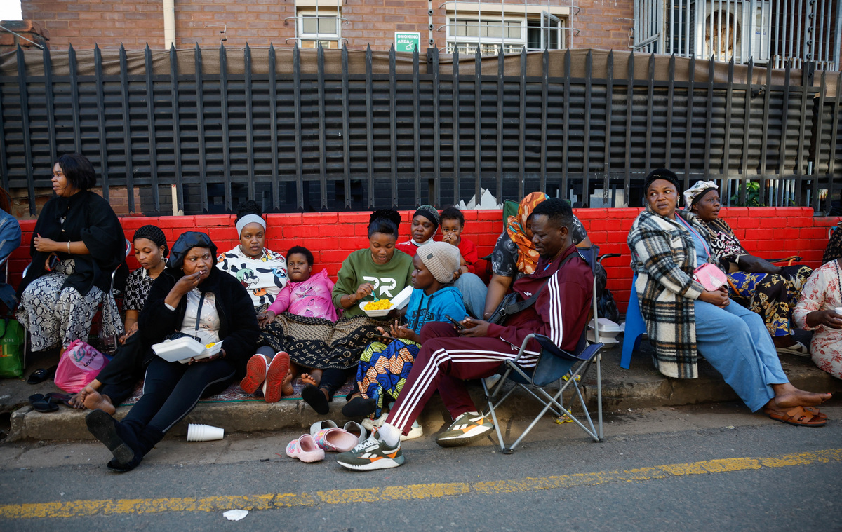 33-year-old Princess Adjei eats a meal on the street while sitting with other foreign nationals who fled their homes amid anti-immigrant protests in Durban, South Africa, June 8, 2026. REUTERS/Rogan Ward