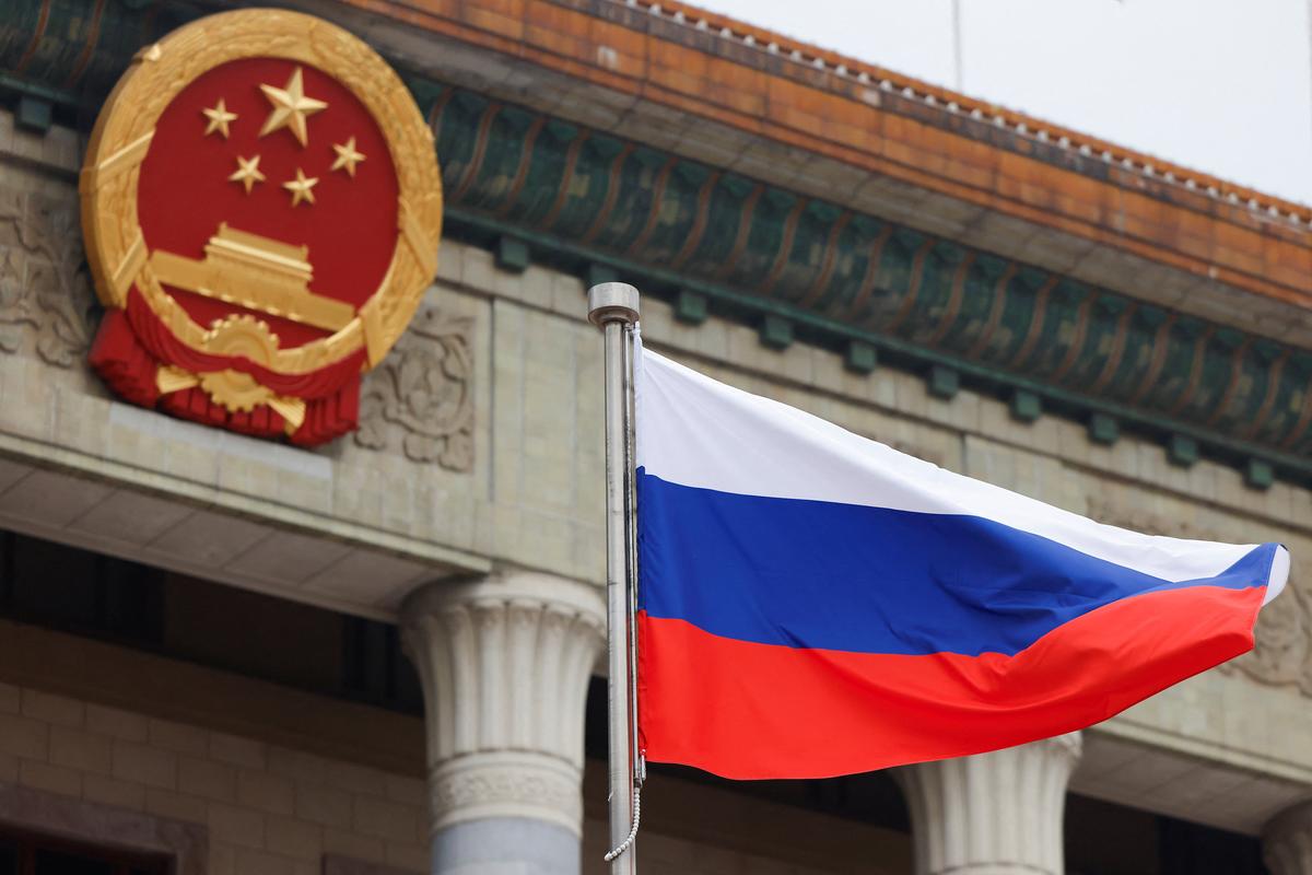The Russian flag flies beside the Chinese national emblem ahead of a welcoming ceremony for Russian President Vladimir Putin at the Great Hall of the People in Beijing, China May 20, 2026. REUTERS/Maxim Shemetov/Pool