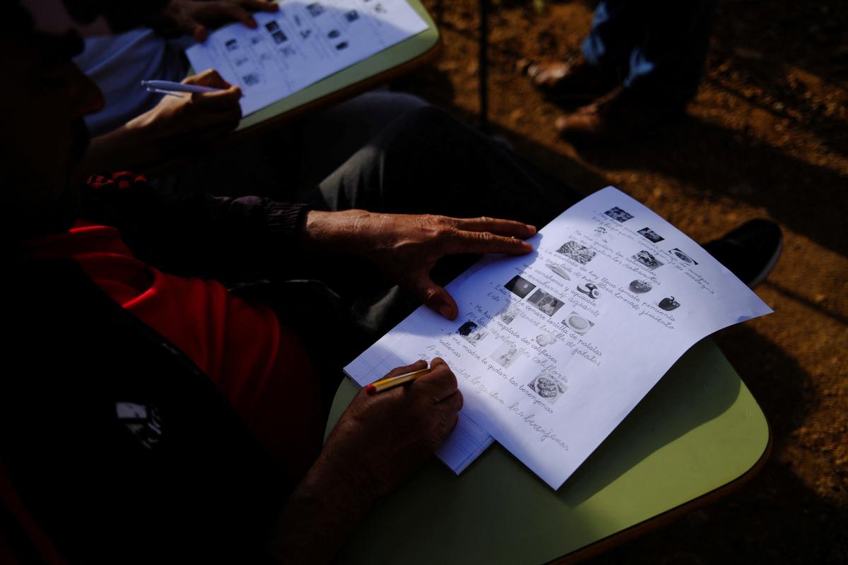 Undocumented migrants from Morocco attend Spanish classes taught by members of the Jesuit Migrant Service in a shanty town after returning of their work inside a plastic-covered greenhouse in Almeria province, home to Europe’s largest concentration of agricultural greenhouses, in Nijar, Spain, May 5, 2026. Undocumented migrants there live without reliable electricity and with limited access to water. REUTERS/Nacho Doce