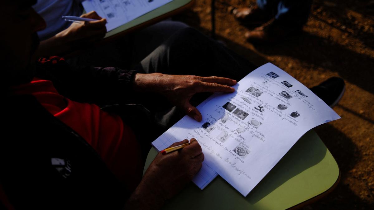 Undocumented migrants from Morocco attend Spanish classes taught by members of the Jesuit Migrant Service in a shanty town after returning of their work inside a plastic-covered greenhouse in Almeria province, home to Europe’s largest concentration of agricultural greenhouses, in Nijar, Spain, May 5, 2026. Undocumented migrants there live without reliable electricity and with limited access to water. REUTERS/Nacho Doce