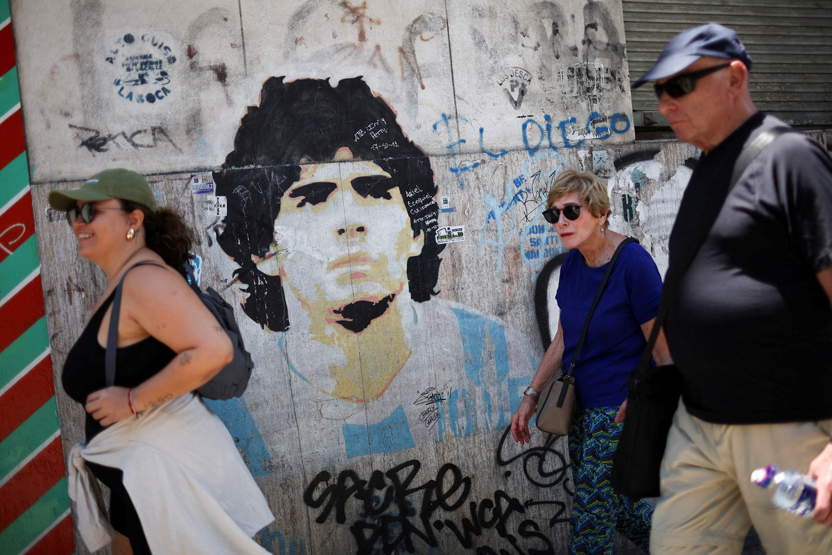 FILE PHOTO: Pedestrians walk past a mural depicting late Argentine soccer legend Diego Armando Maradona, ahead of the FIFA World Cup draw, in Buenos Aires, Argentina December 5, 2025. REUTERS/Agustin Marcarian/File Photo
