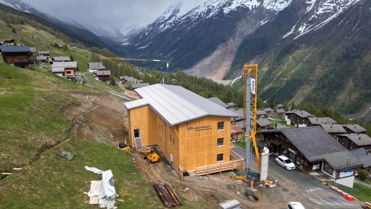 A drone view shows the newly built Momentum Lodge in Lauchernalp, above the village of Wiler, overlooking the landslide area nearly a year after a massive rock and ice slide triggered by the collapse of the Birch Glacier destroyed much of the village of Blatten, Switzerland, May 21, 2026. REUTERS/Cecile Mantovani