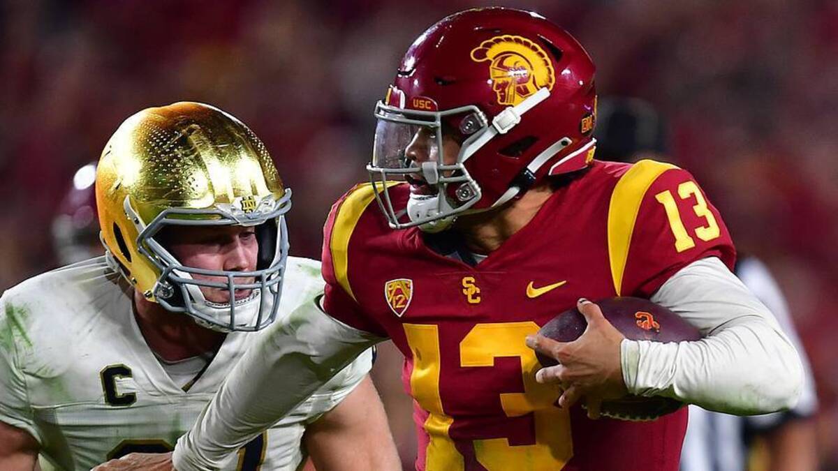  Nov 26, 2022; Los Angeles, California, USA; Southern California Trojans quarterback Caleb Williams (13) runs the ball ahead of Notre Dame Fighting Irish linebacker JD Bertrand (27) during the second half at the Los Angeles Memorial Coliseum. Mandatory Credit: Gary A. Vasquez-Imagn Images | Gary A. Vasquez-Imagn Images 