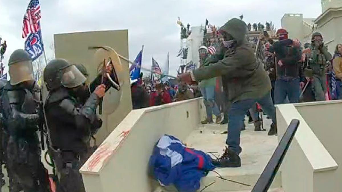 En esta imagen de la cámara de video corporal de un oficial del Departamento de Policía Metropolitana de Washington, y contenida en la declaración de hechos que respalda una orden de arresto contra Mark Ponder, Ponder golpea a un oficial con un poste en el frente oeste del Capitolio de EE. UU. el 6 de enero. , 2021, en Washington. Ponder, el hombre que atacó a policías con postes durante los disturbios en el Capitolio de EE. UU. fue sentenciado a más de cinco años de prisión el 26 de julio de 2022. (Departamento de Justicia vía AP)
