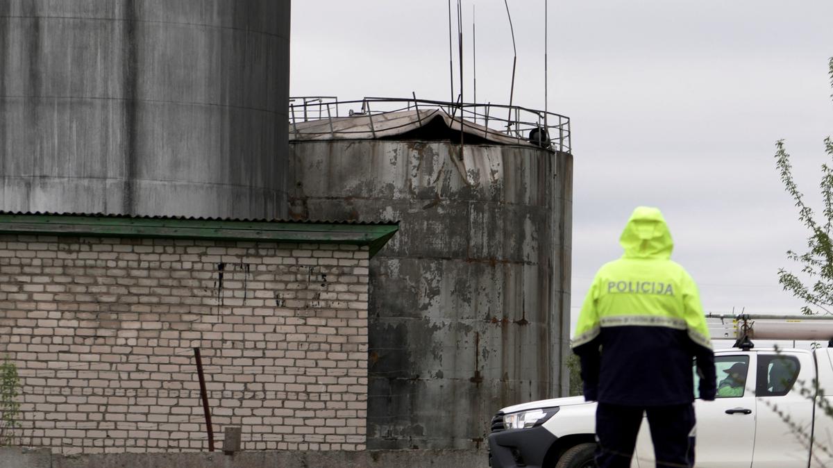 Police officer looks towards damage to an oil tank after drones crashed at a storage facility in Rezekne, Latvia, May 7, 2026. REUTERS/Janis Laizans
