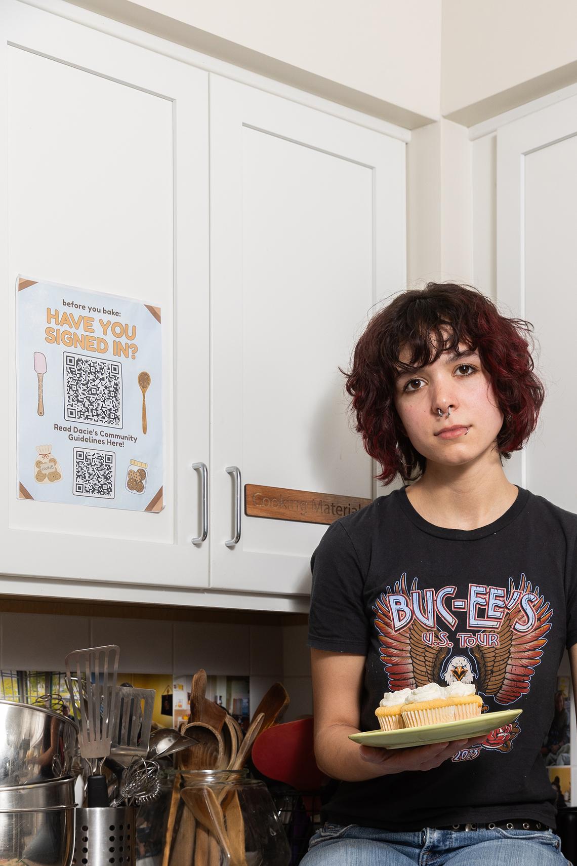 Maya Allen, a junior from San Antonio, with a plate of cupcakes at the Dacie Moses House, Carleton College's cookie house in Northfield, Minn., March 30, 2026. For decades, Carleton College has kept a place where students and others can come, bake and share. (Liam James Doyle/The New York Times)