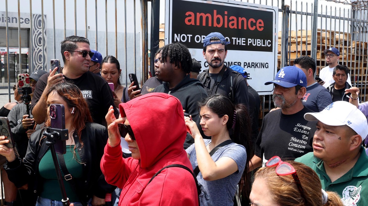People gather in front of Ambiance Apparel after several employees were taken into custody by federal agents in the Garment District in downtown Los Angeles in June 2025. (Genaro Molina/Los Angeles Times/TNS)